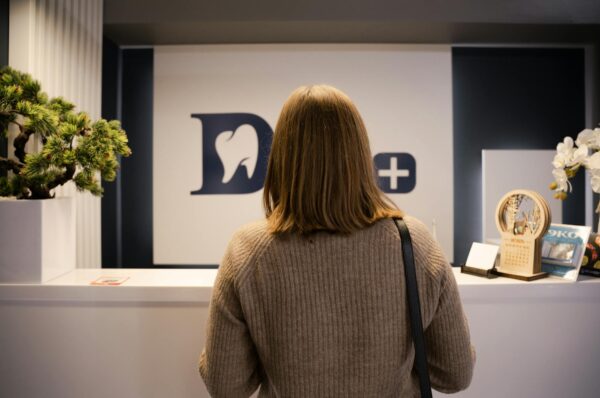 woman in brown sweater in front of a reception desk